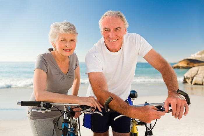 Älterer Mann und Frau stehen neben ihren Fahrrädern